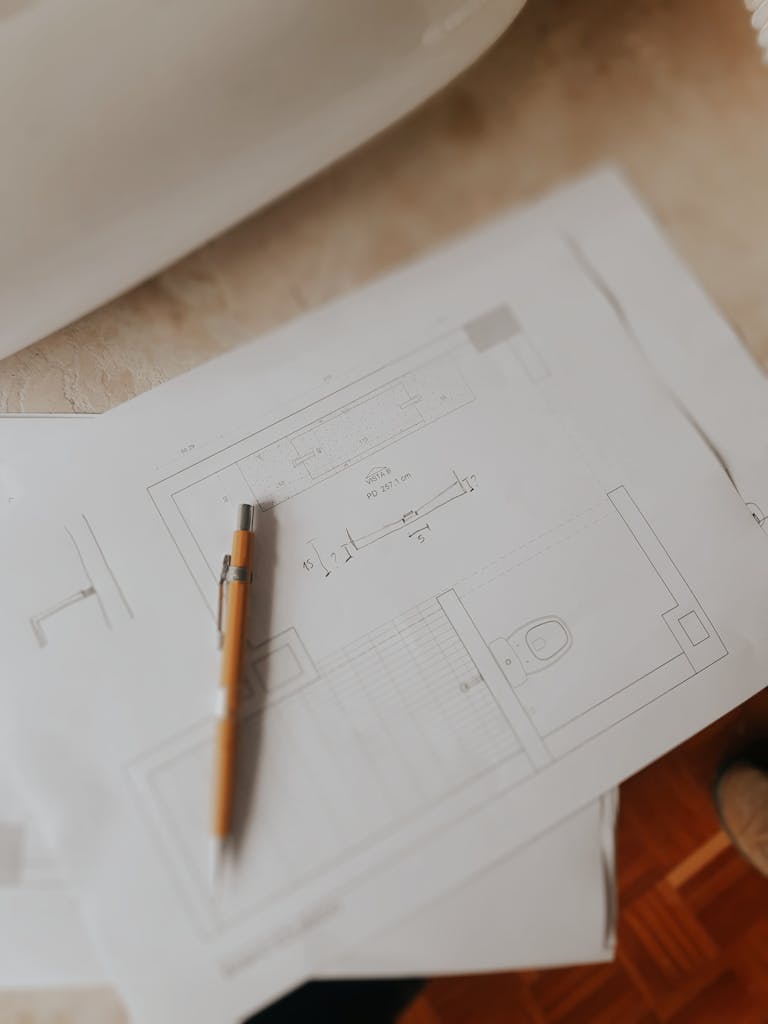 Top view of architectural floor plans and a pen on a desk, ideal for design concepts.
